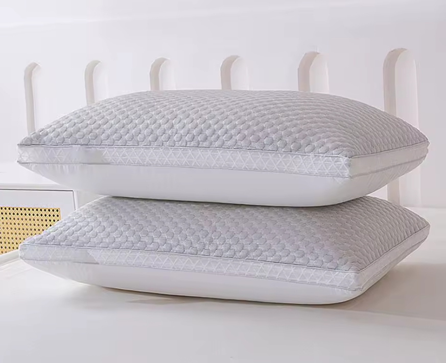 Hands adjusting a cooling pillow on a bed